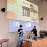 zdjęcie: trzy osoby na tle prezentacji multimedialnej z tekstem: „Plusy?”