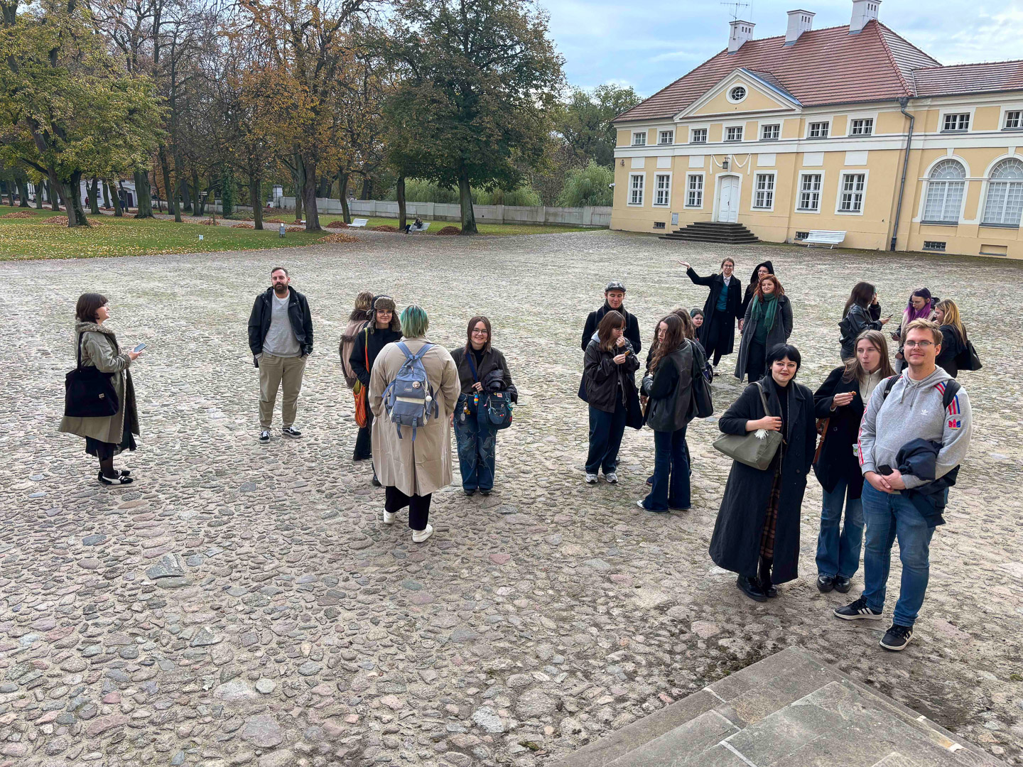 zdjęcie: grupa osób pozuje przed pałacem