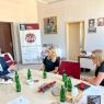 zdjęcie: trzy osoby siedzą przy stole w biurze, prowadząc rozmowę