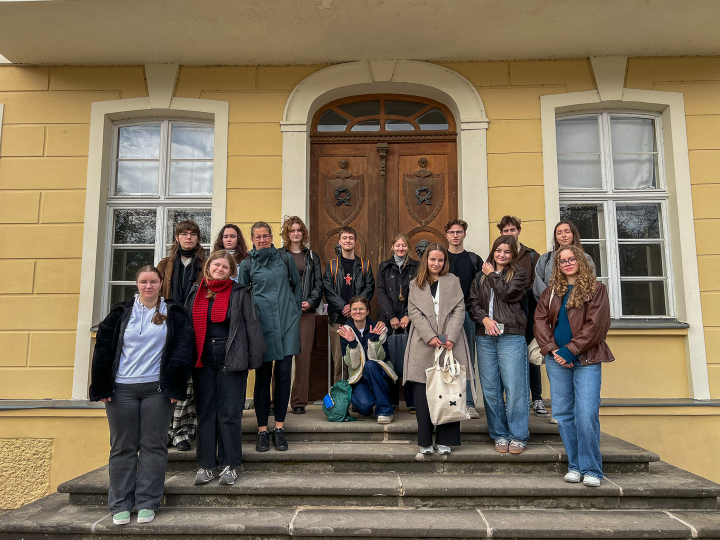 zdjęcie: grupa osób pozuje przed pałacem