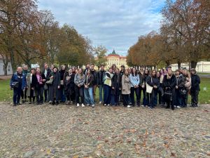 zdjęcie: grupa osób pozuje przed pałacem