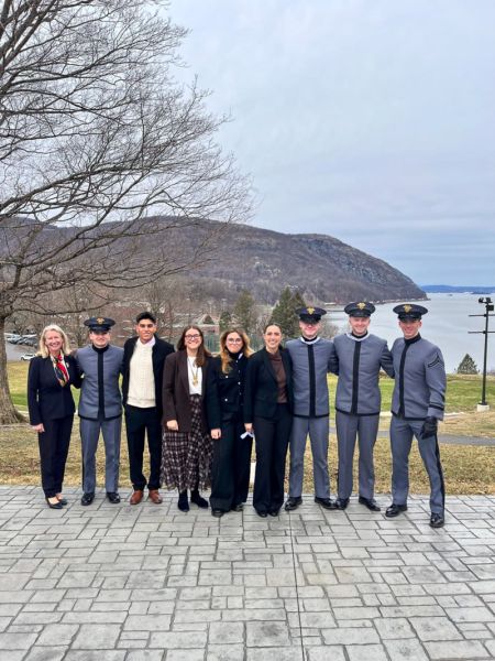 photograph: a group of nine people, four of them dressed in uniform, pose for a photograph in the open
