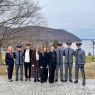 photograph: a group of nine people, four of them dressed in uniform, pose for a photograph in the open