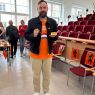 zdjęcie: dr Mikołaj Buczak prezentuje w stronę obiektywu słodkości przygotowane dla uczestniczących w wydarzeniu