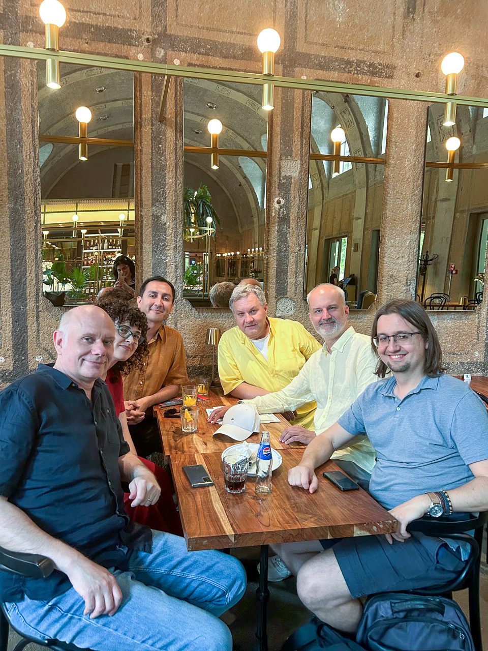 photograph: six persons pose for a photograph by a restaurant table