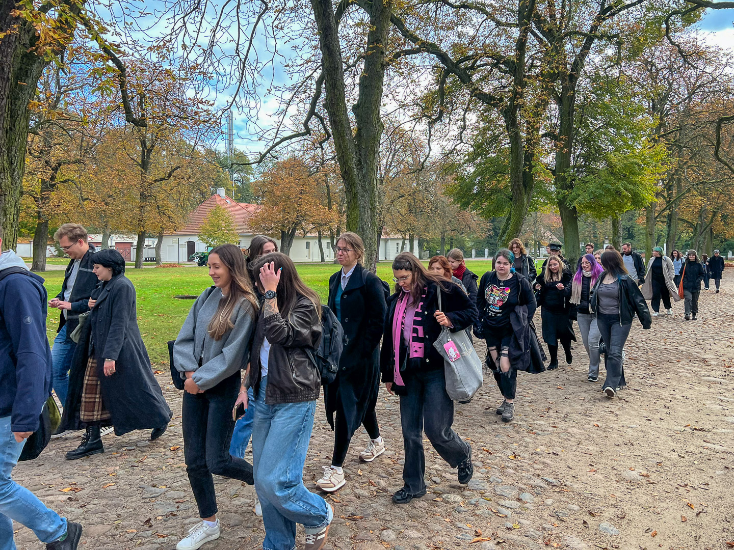 zdjęcie: grupa osób przechadza się po ogrodzie