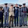 photograph: a group of nine people, four of them dressed in uniform, pose for a photograph in the open