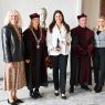 photograph: five persons pose for a photograph, one of them holding a diploma and a statuette