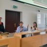 photograph: three persons sitting behind a desk in a lecture hall