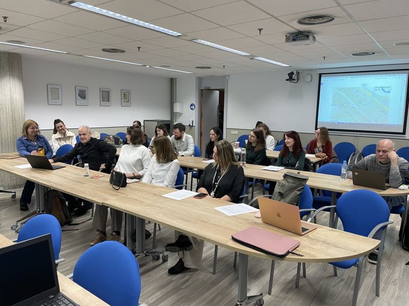 photograph: a group of fifteen people sitting behind desks in a seminar room