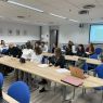 photograph: a group of fifteen people sitting behind desks in a seminar room