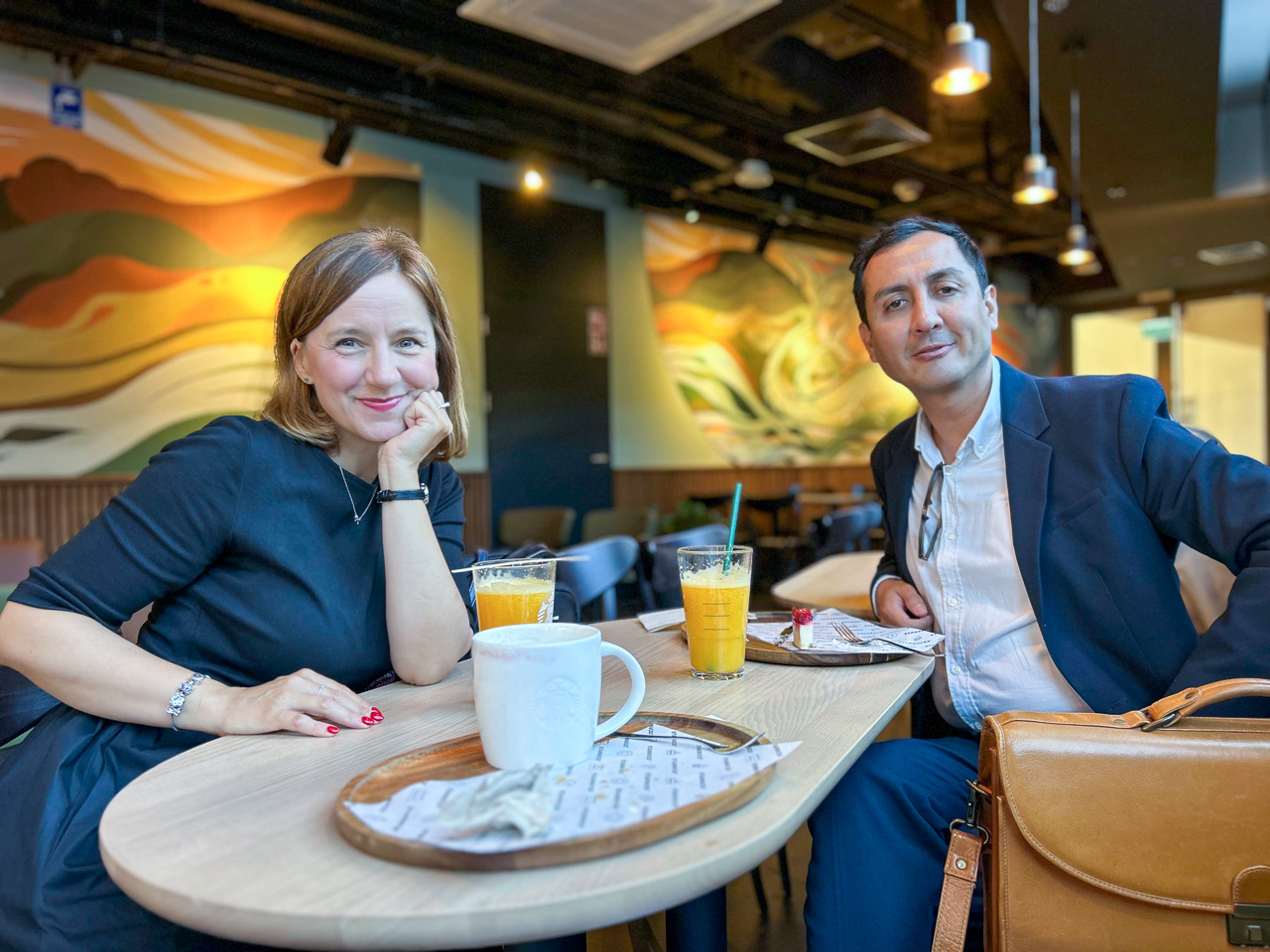 photograph: two persons pose for a photograph by a café table