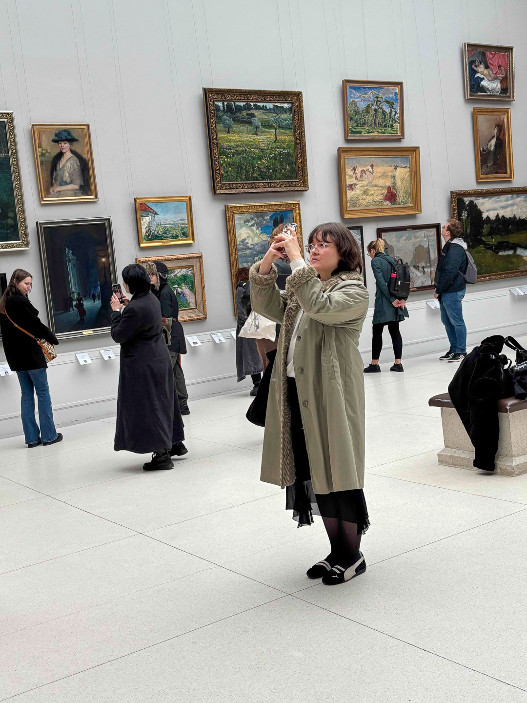 zdjęcie: osoba ogląda obrazy w galerii