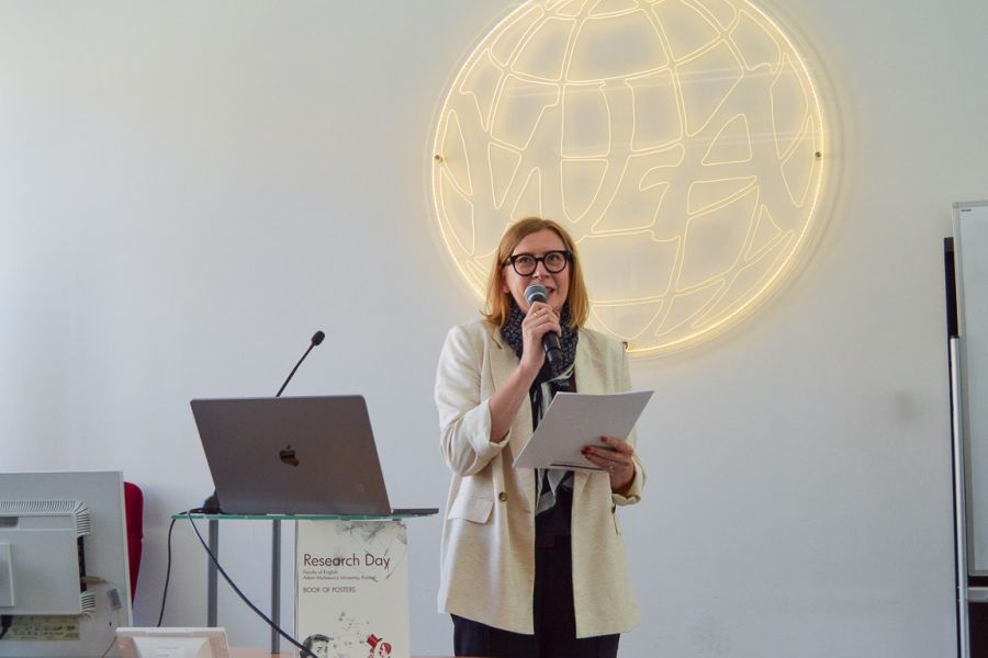 photograph: person with a microphone in hand addresses the audience (who are out of frame)