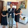 photograph: three persons pose for a photograph in an office