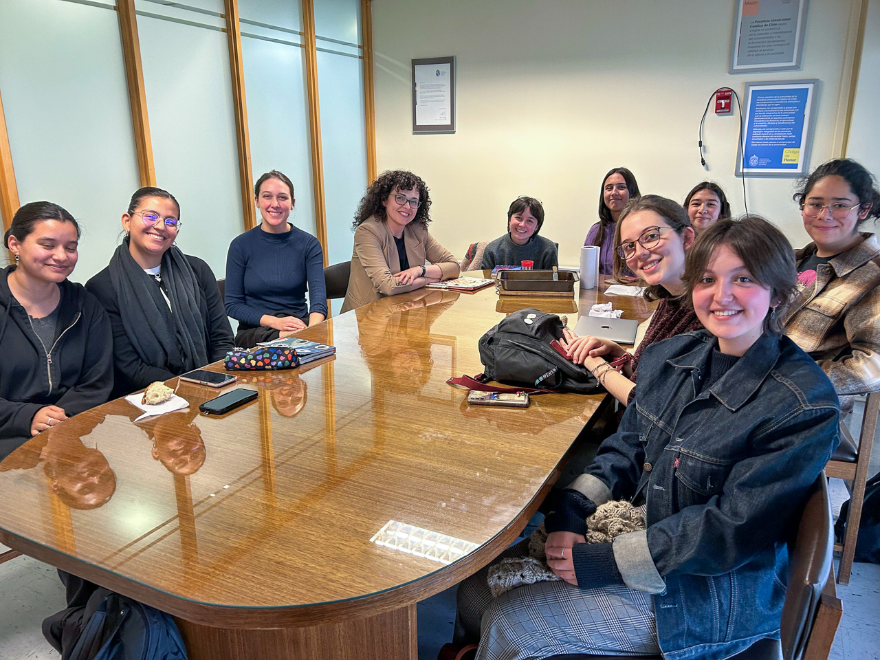 photograph: ten persons pose for a photograph by a table in a seminar room