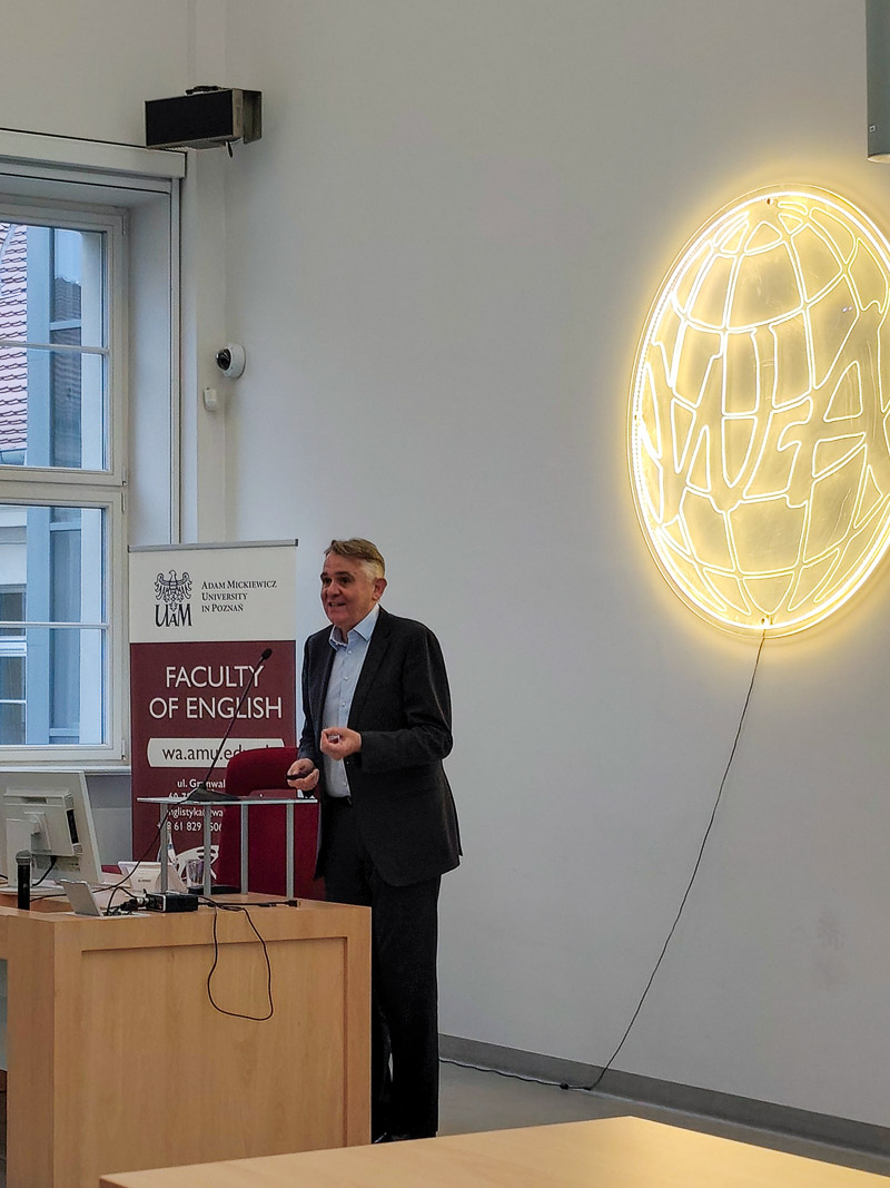 zdjęcie: osoba stoi za mównicą w sali wykładowej