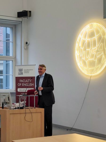 zdjęcie: osoba stoi za mównicą w sali wykładowej