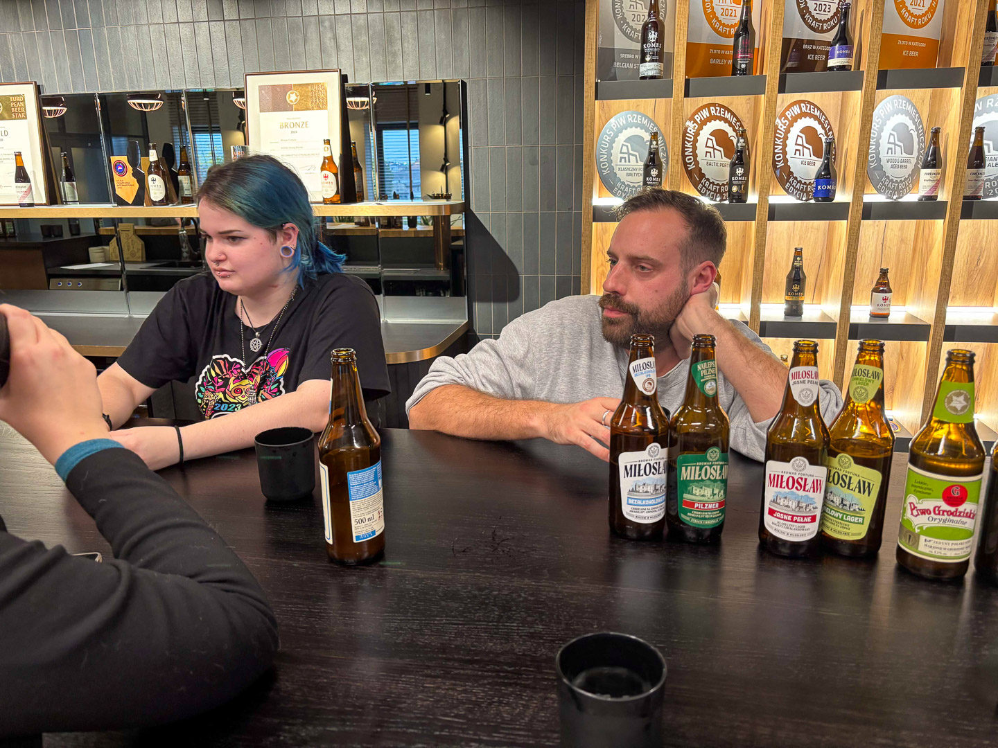 zdjęcie: grupa osób dyskutuje przy produktach browarnych