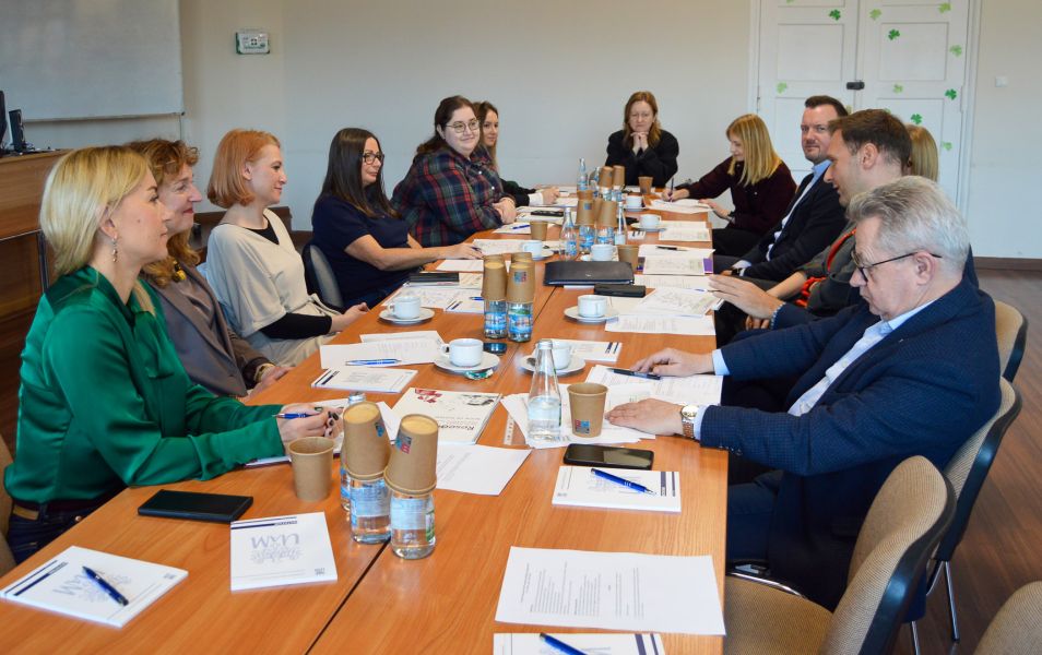 zdjęcie: grupa dwanaściorga osób przy stole koncerencyjnym w sali seminaryjnej