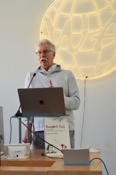 photograph: person standing behind a pulpit addresses the audience (who are out of frame)