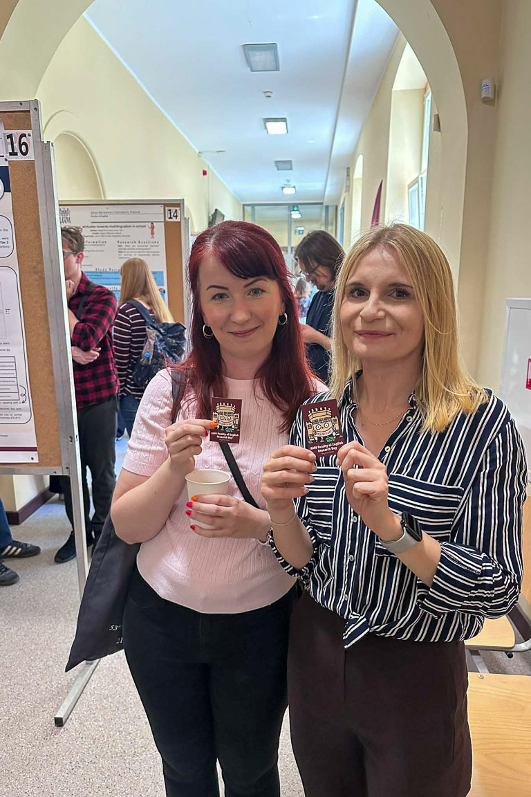 photograph: two persons posing with promotional stickers of the event