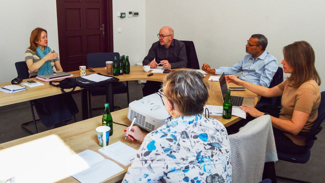 photograph: a group of five people sitting by a conference table