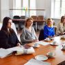 photograph: a group of people sit by a table in a seminar room