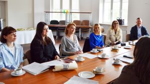 photograph: a group of people sit by a table in a seminar room