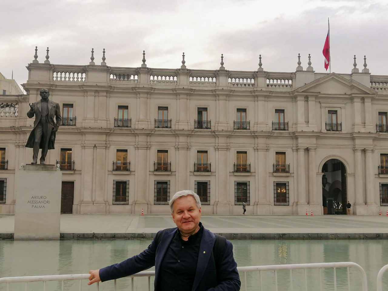photograph: a person poses for a photograph in front of a building