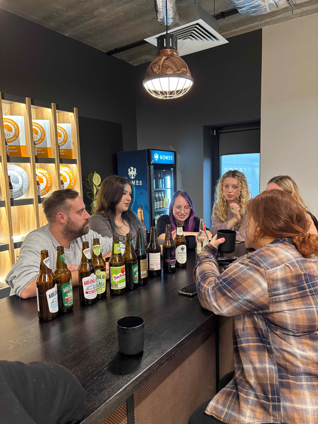 zdjęcie: grupa osób dyskutuje przy produktach browarnych