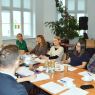 zdjęcie: grupa dwanaściorga osób przy stole koncerencyjnym w sali seminaryjnej