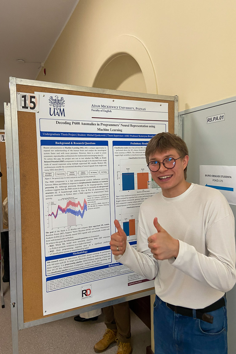 photograph: person posing in front of a conference poster stand