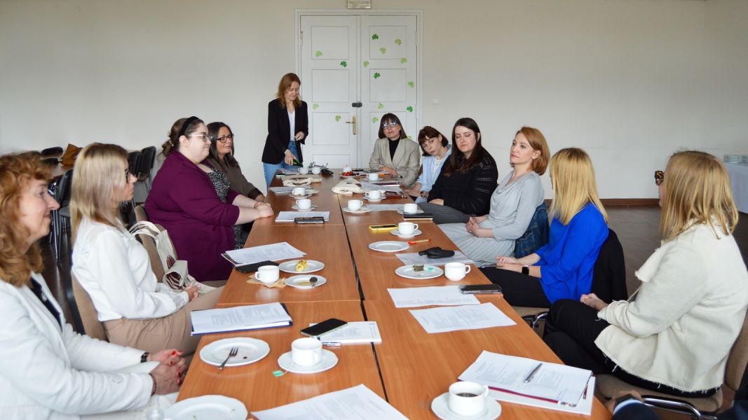 photograph: a group of people sit by a table in a seminar room