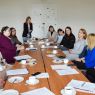 photograph: a group of people sit by a table in a seminar room