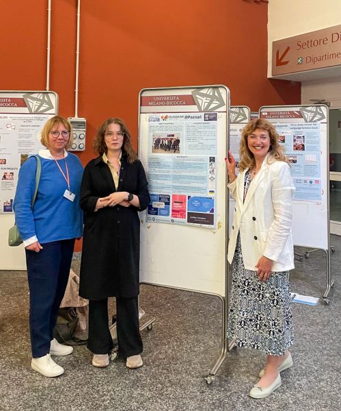 photograph: three persons pose next to conference poster stands