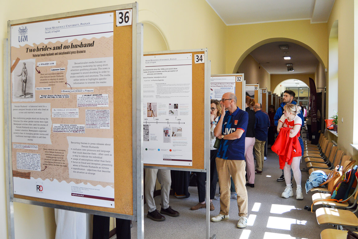 photograph: hallway with conference poster stands and some people looking at their content