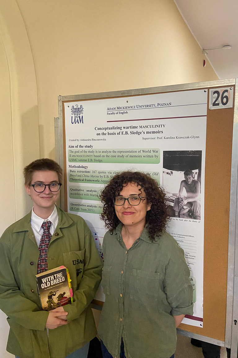 photograph: two persons posing in front of a conference poster stand
