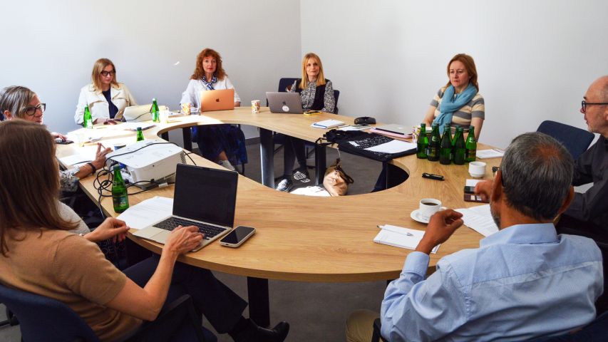 photograph: a group of eight people sitting by a conference table