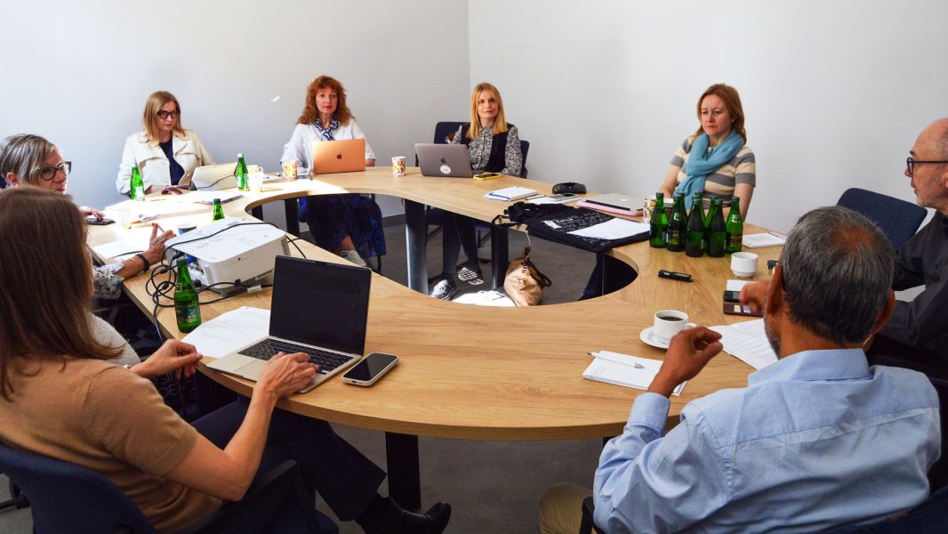 photograph: a group of eight people sitting by a conference table