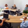 photograph: a group of eight people sitting by a conference table