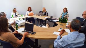 photograph: a group of eight people sitting by a conference table