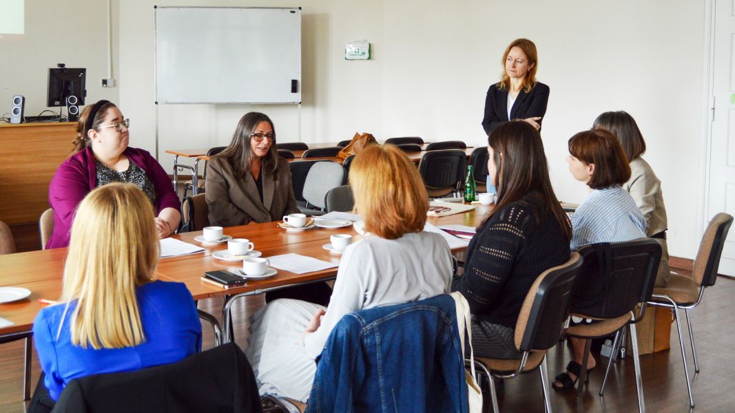 photograph: a group of people sit by a table in a seminar room