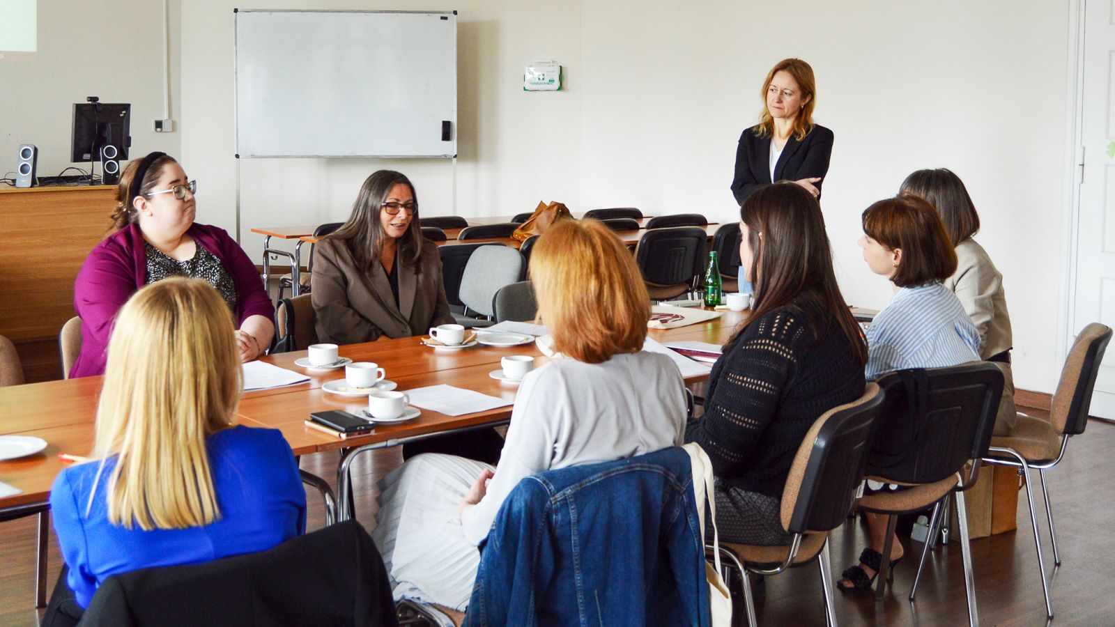 photograph: a group of people sit by a table in a seminar room