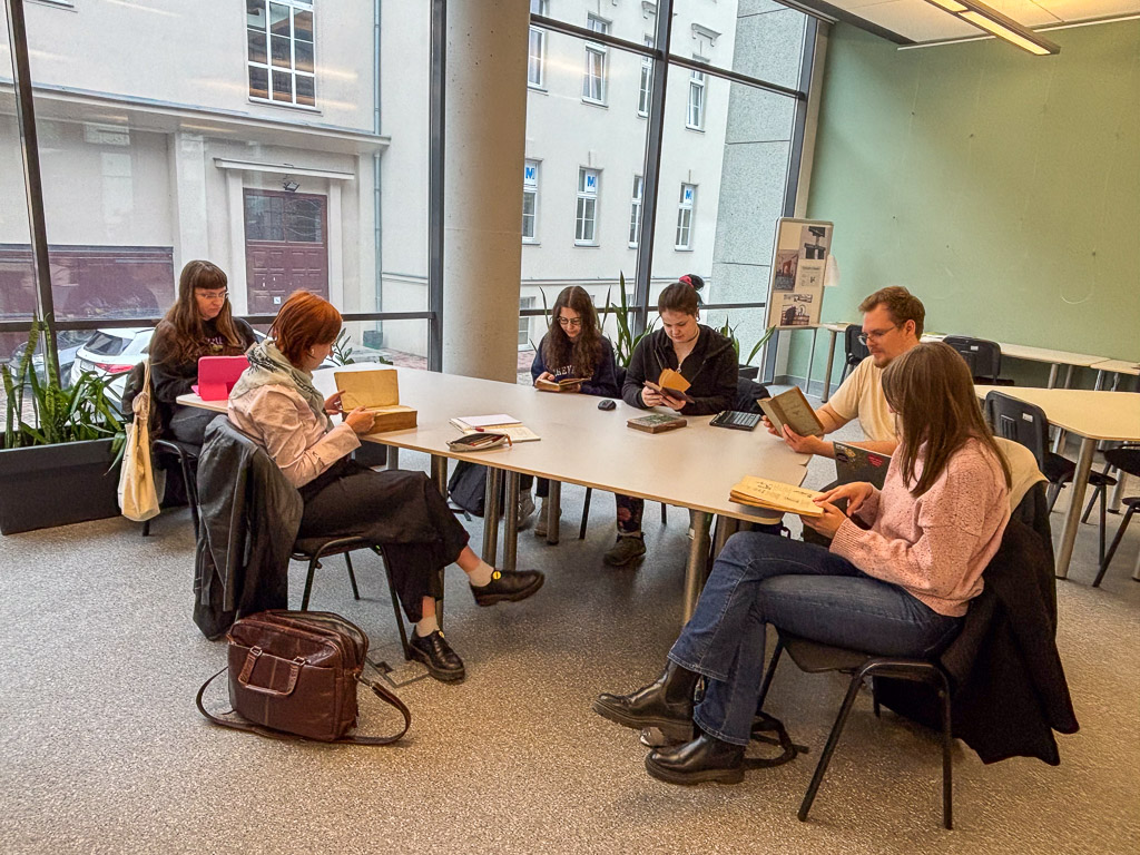 studenci oglądający stare książki przy stole