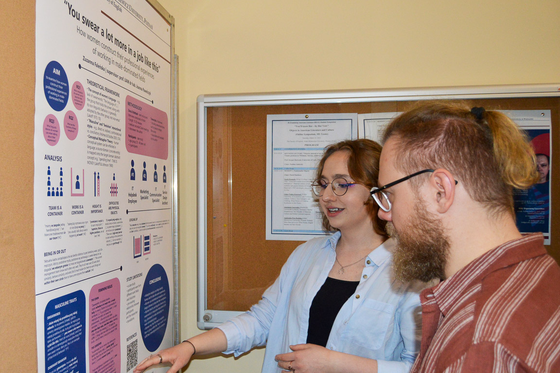 photograph: two persons studying the content of a conference poster