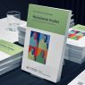 zdjęcie: stos egzemplarzy książki „Postcolonial Studies” wyeksponowany na stole podczas wydarzenia