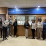 photograph: a group of nine people posing for a photograph in a building hall, behind them is a display with the caption in Catalan {Museu de Fonètica}