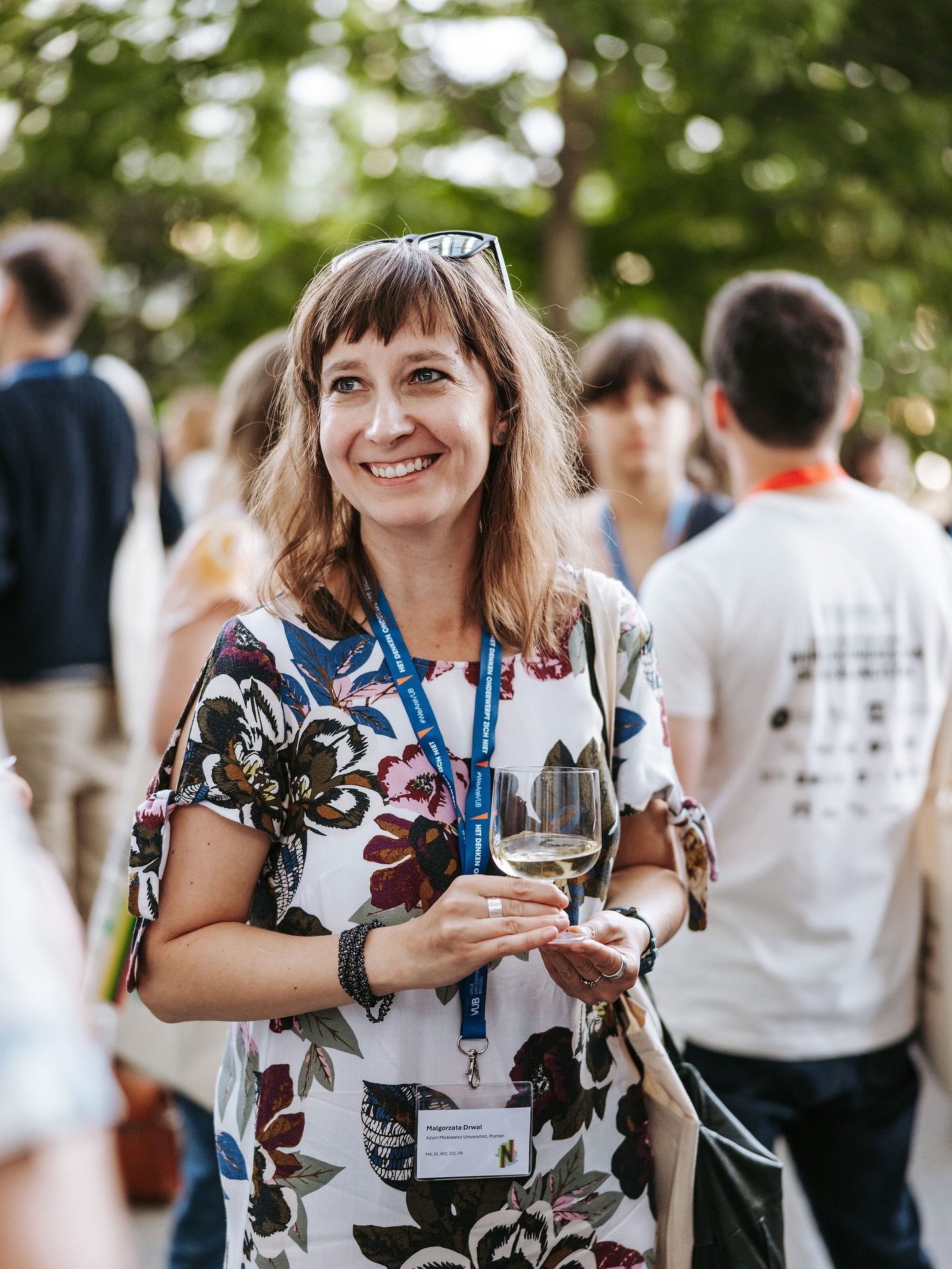 Dr Małgorzata Drwal w ujęciu z półprofilu trzymająca w rękach kieliszek wina