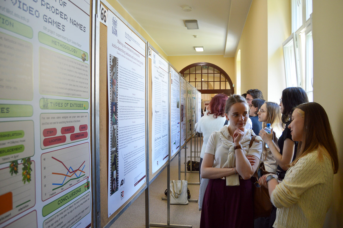 photograph: hallway with conference poster stands and some people looking at their content